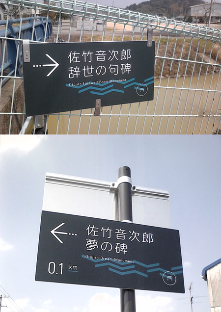 設置された音次郎看板 維新博の音次郎看板。竹島集会所の川のほとりに、フェンスがあります。そこに1枚は固定されています。「佐竹音次郎 辞世の句碑」と書かれています。大きさは40cmかける18cmほどです。焦げ茶色に白い文字です。川の流れのような模様が入っています。もう1枚の写真は竹島神社入り口にある看板です。「佐竹音次郎 夢の碑」と書かれています。デザインは同じです。下から見上げた写真で、青空がバックです。